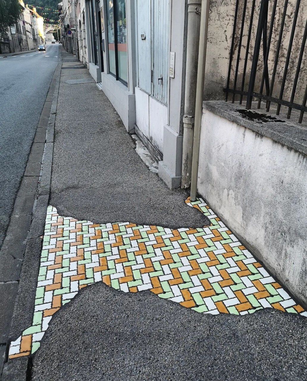 Вуличний художник перетворює міські ями на кольорову мозаїку