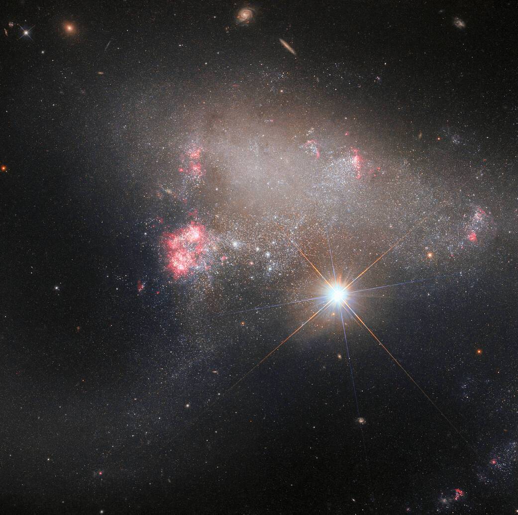 Утворилась внаслідок зіткнення: астрономи показали ефектний кадр неправильної галактики з надзвичайною зіркою (фото)