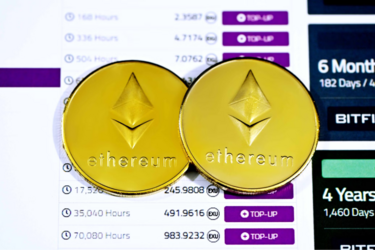 Две золотые монеты Ethereum на фоне графиков