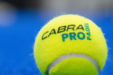 Жовтий тенісний м'яч на синьому корті