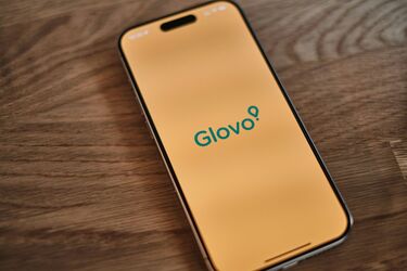 Смартфон із відкритим додатком Glovo на жовтому фоні