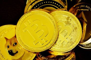 Золоті монети Bitcoin і Dogecoin, що символізують криптовалютний ринок