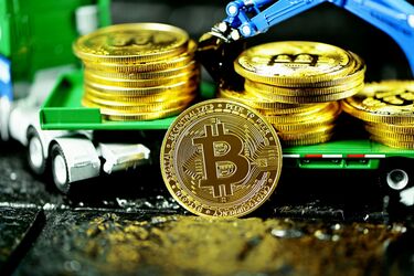 Золоті монети з логотипом Bitcoin на платформі ігрової вантажівки, що символізують криптовалютні інвестиції