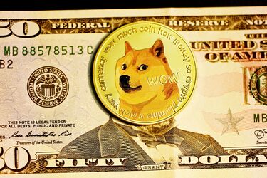 Золота монета Dogecoin на тлі п’ятдесятидоларової банкноти США