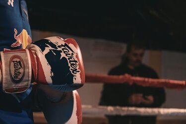 Боксер в перчатках Fairtex готовится к бою в ринге
