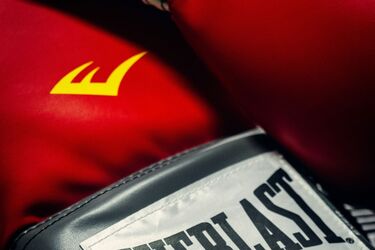 Красные боксерские перчатки Everlast на темном рифленом покрытии
