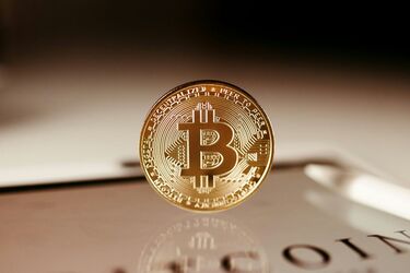 Золота монета Bitcoin на відображеній поверхні у фокусі