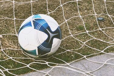 Футбольный мяч в воротах на поле