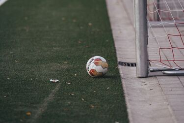 Футбольний м'яч біля воріт на порожньому полі